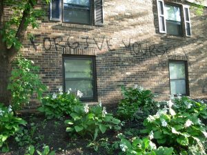 The words forgive yourself written on the side of a brick building.